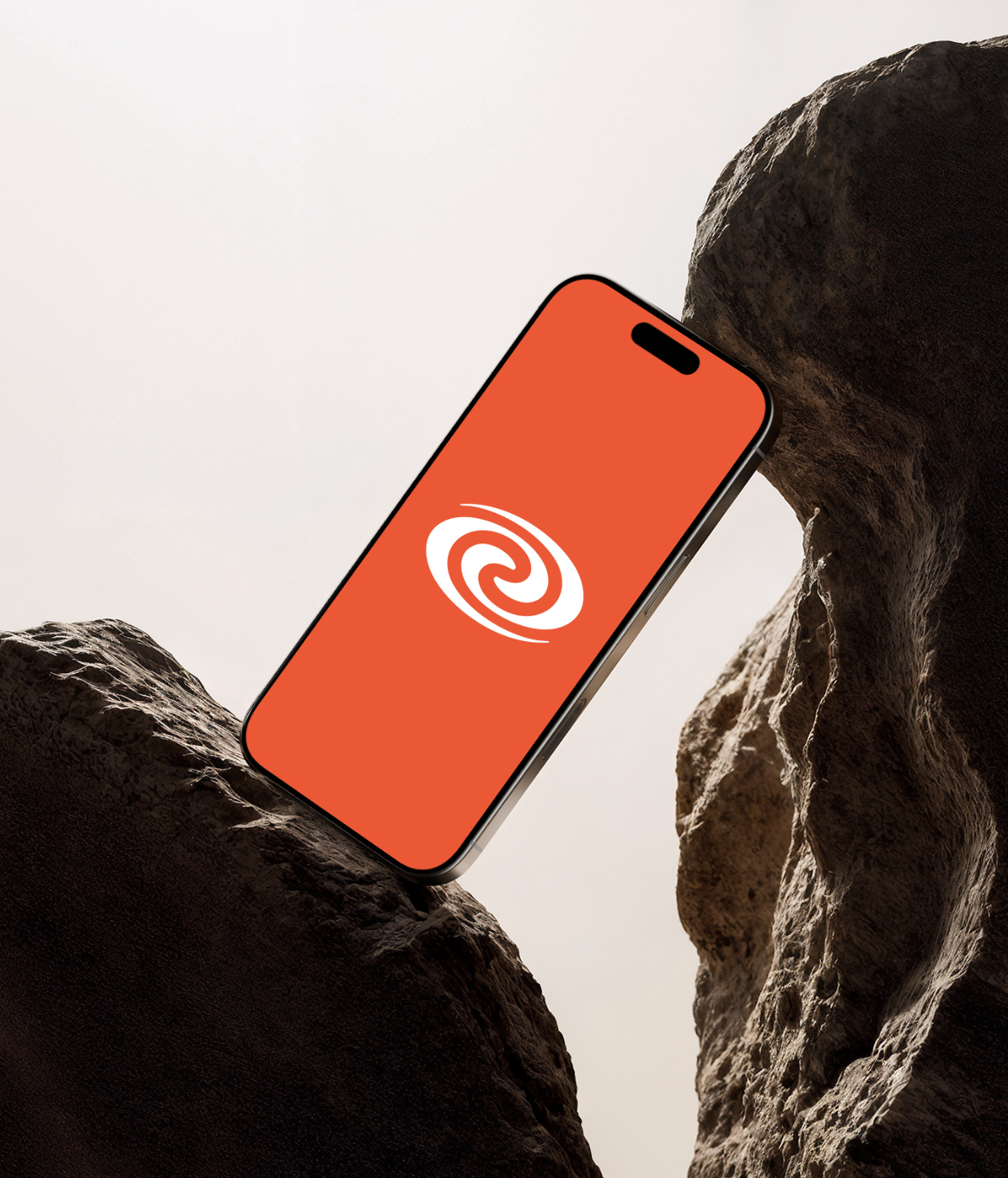 ParaBuyer brand splash — spiral mark on cyan-orange field — on iPhone wedged in stone arch